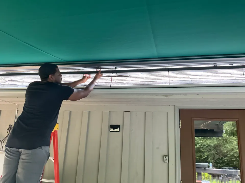Vantage installer working beneath a green retractable awning