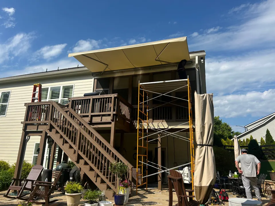 Retractable awning being installed above an elevated residential deck